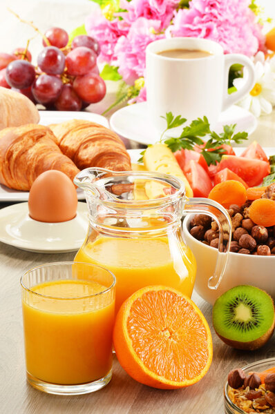 Breakfast with coffee, orange juice, croissant, egg, vegetables