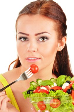 Sebze salatası yiyen genç bir kadın.