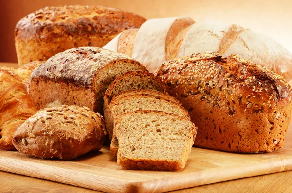 Rieten mand met brood en broodjes samenstelling met brood en broodjes. bakken producten. — Stockfoto