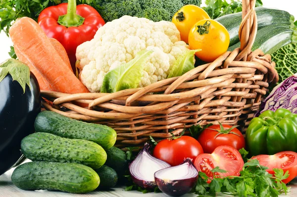 Variety of fresh organic vegetables in wicker basket — Stock Photo, Image