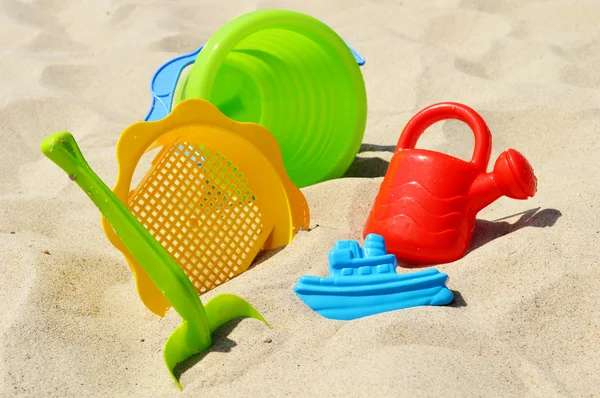 Plástico crianças brinquedos na praia de areia — Fotografia de Stock