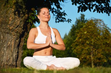yoga, meditasyon sırasında genç kadın parkta