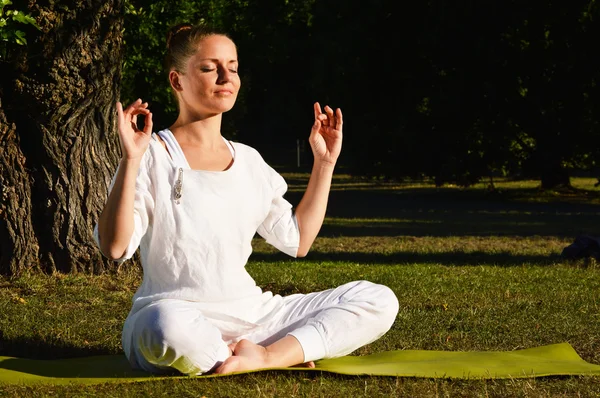 Giovane donna durante la meditazione yoga nel parco — Foto Stock