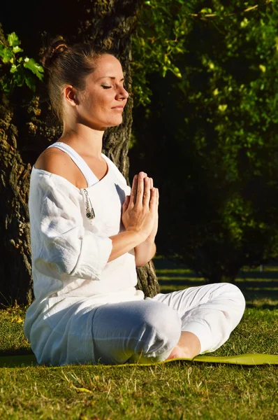 Mujer joven durante la meditación de yoga en el parque —  Fotos de Stock