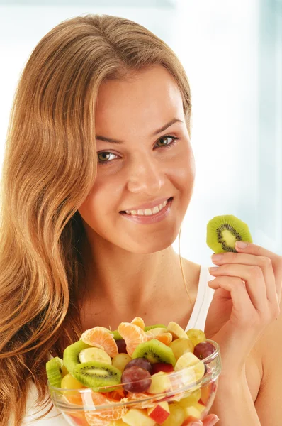 Mladá žena jíst ovocný salát — Stock fotografie