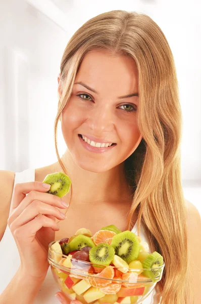 Mujer joven comiendo ensalada de frutas —  Fotos de Stock