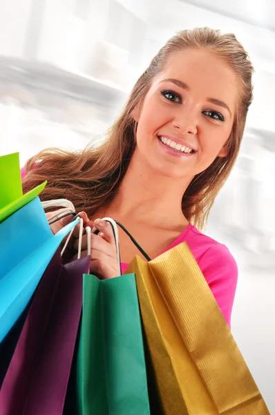Młoda kobieta z torbami na zakupy w sklepie — Zdjęcie stockowe