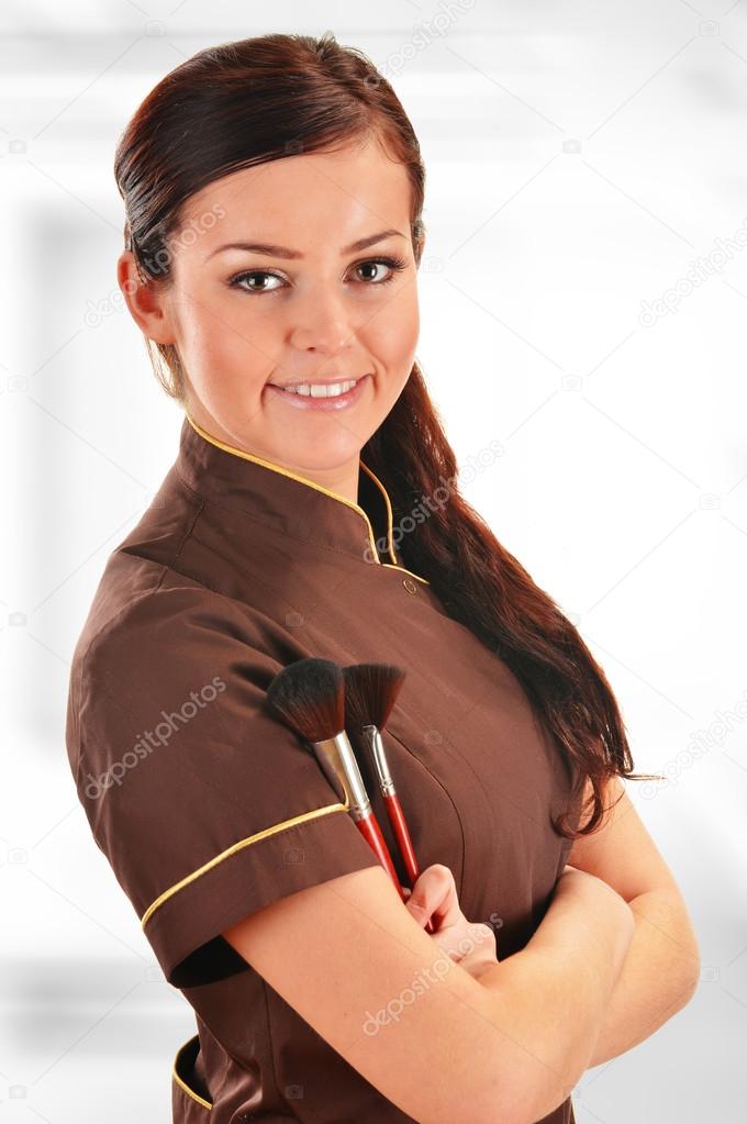 Professional beautician holding brushes