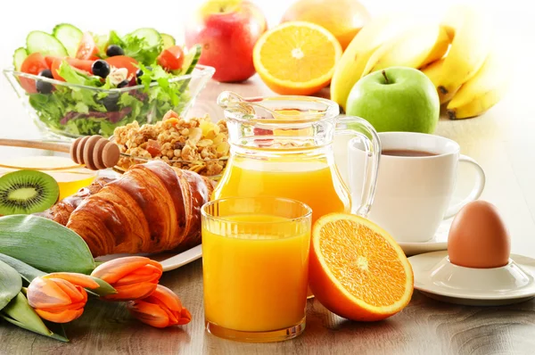 Morgenmad med kaffe, juice, croissant, salat, muesli og æg - Stock-foto