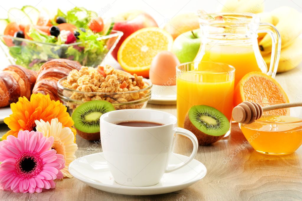 Breakfast with coffee, juice, croissant, salad, muesli and egg