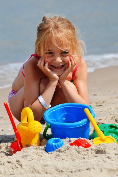 Little girl playing on the sand beach — Stock Photo, Image