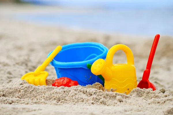 Giocattoli di plastica per bambini sulla spiaggia di sabbia — Foto Stock