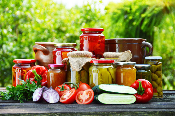 Jars of pickled vegetables in the garden. Marinated food