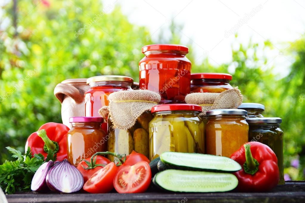 Jars of pickled vegetables in the garden. Marinated food