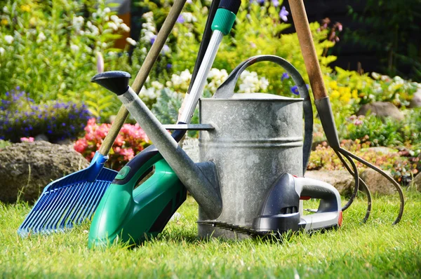 Regar lata e ferramentas no jardim — Fotografia de Stock