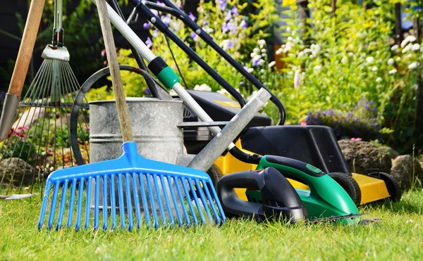 Watering can and tools in the garden — Stock Photo, Image