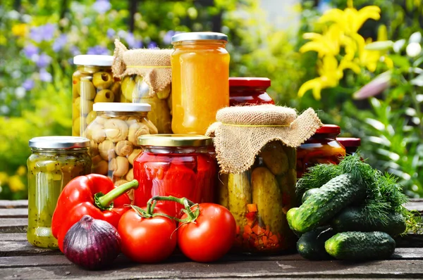 Jars of pickled vegetables in the garden. Marinated food — Stock Image Jars of pickled vegetables in the garden. Marinated food Stock Picture