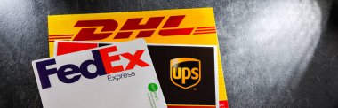POZNAN, POL - 26 DEC 2021: Dünyadaki 3 popüler kurye servisinin zarfları: UPS, FedEx ve DHL