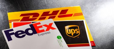 POZNAN, POL - 26 DEC 2021: Dünyadaki 3 popüler kurye servisinin zarfları: UPS, FedEx ve DHL