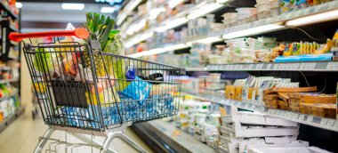 Süpermarkette market ürünleriyle dolu bir alışveriş arabası.