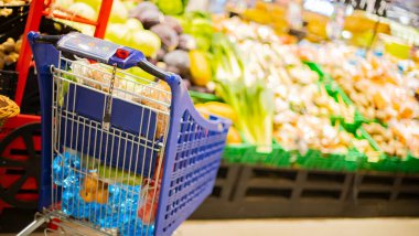Süpermarkette market ürünleriyle dolu bir alışveriş arabası.