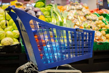 Süpermarkette market ürünleriyle dolu bir alışveriş arabası.