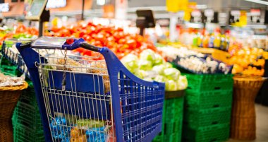 Süpermarkette market ürünleriyle dolu bir alışveriş arabası.