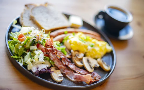 Çırpılmış yumurta, pastırma, sosis ve restoran masasında tost.