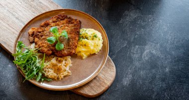 Patates püresi ve lahana kırıntılarıyla kaplı domuz pirzolası.