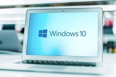 POZNAN, POL - MAR 15, 2021: Microsoft tarafından geliştirilen, pazarlanan ve satılan grafiksel işletim sistemi Windows 10 'un logosunu gösteren dizüstü bilgisayar