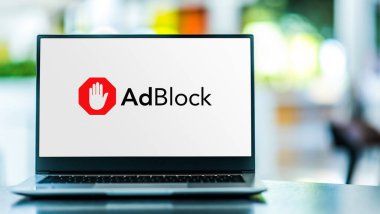 POZNAN, POL - MAR 15, 2021: Google Chrome, Apple Safari, Firefox, Opera ve Microsoft Edge için bir içerik filtreleme ve reklam engelleme tarayıcı uzantısı olan AdBlock logosu gösteren dizüstü bilgisayar