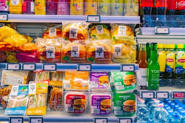 POZNAN, POL - 12 MAR 2022: Bir marketteki ticari buzdolabında sergilenen önceden paketlenmiş yiyecek ve içecekler