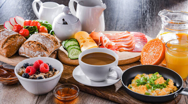 Breakfast served with coffee, orange juice, scrambled eggs, cereals, ham and cheese.