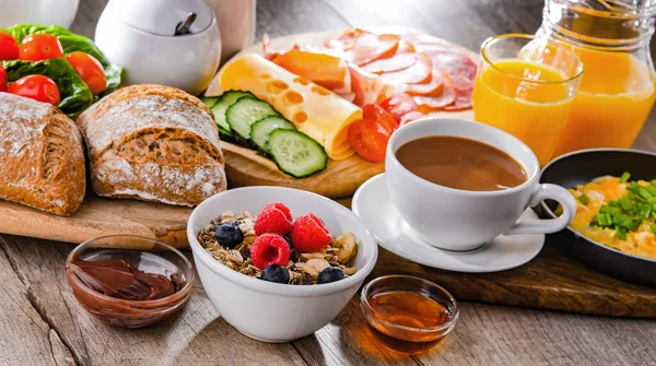 Kahvaltının yanında kahve, portakal suyu, omlet, tahıl, jambon ve peynir..