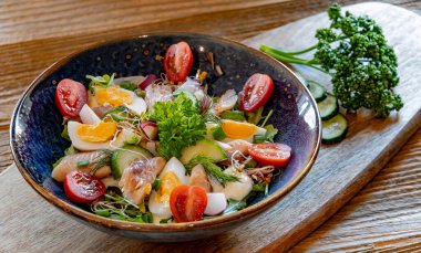 Bir tabak alabalık ve yumurtalı sebze salatası..