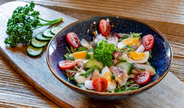 Bir tabak alabalık ve yumurtalı sebze salatası..