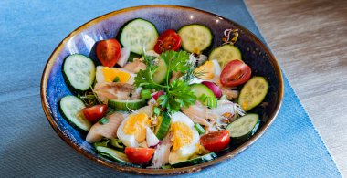 Bir tabak alabalık ve yumurtalı sebze salatası..