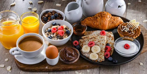 Πρωινό Σερβίρεται Καφέ Χυμό Πορτοκαλιού Τηγανίτες Κρουασάν Δημητριακά Και Φρούτα — Φωτογραφία Αρχείου