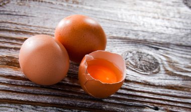 Tahta bir masada üç tavuk yumurtasıyla kompozisyon..