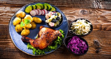 Fırında tavuk budu, patates ve sebze salatası.