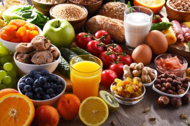 Ahşap mutfak masasında çeşitli organik gıda ürünleri..