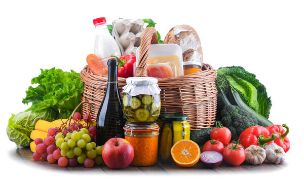 Wicker basket with assorted grocery products including fresh vegetables and fruits