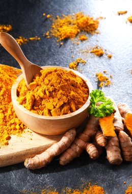 Bir kase zemin zerdeçal ve taze rhizomu ile kompozisyon.