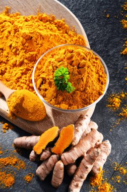 Bir kase zemin zerdeçal ve taze rhizomu ile kompozisyon.