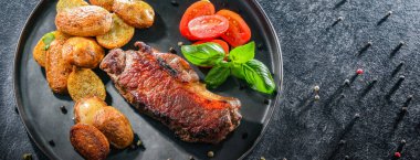 Kızarmış biftek, kızarmış patates ve vişneli domates..