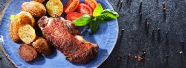 Kızarmış biftek, kızarmış patates ve vişneli domates..