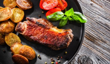 Kızarmış biftek, kızarmış patates ve vişneli domates..