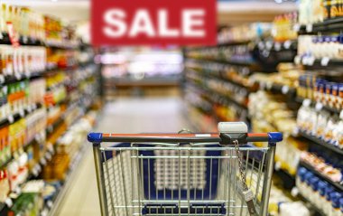 Süpermarketin rafında bir alışveriş arabası.