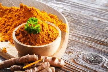 Bir kase zemin zerdeçal ve taze rhizomu ile kompozisyon.