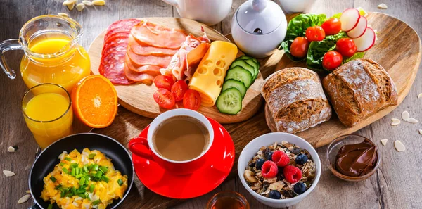 Kahvaltının yanında kahve, portakal suyu, omlet, tahıl, jambon ve peynir..